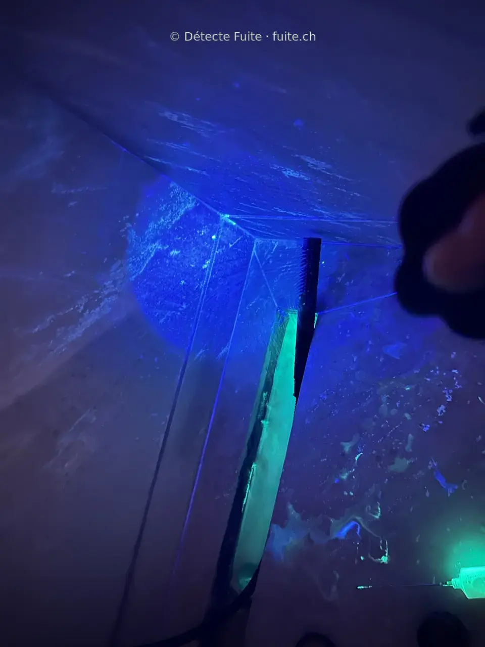 Traceur fluorescent visible sous une lampe UV dans un intérieur
